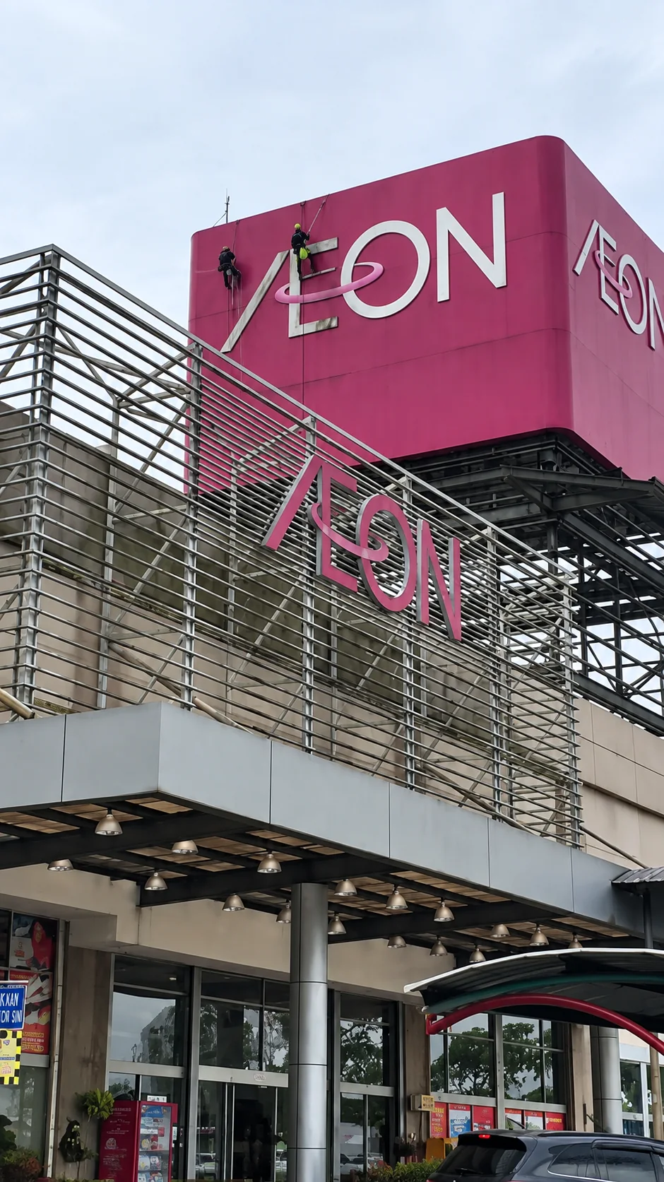 Vertical Pro rope access technician working near an elevated signboard